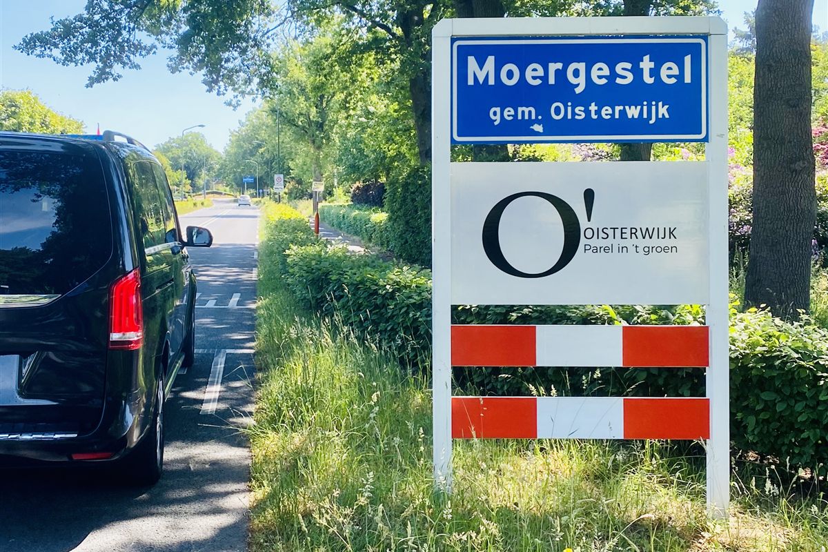 Mercedes V-Klasse van TAXI TILBURG bij het plaatsnaambord van Moergestel